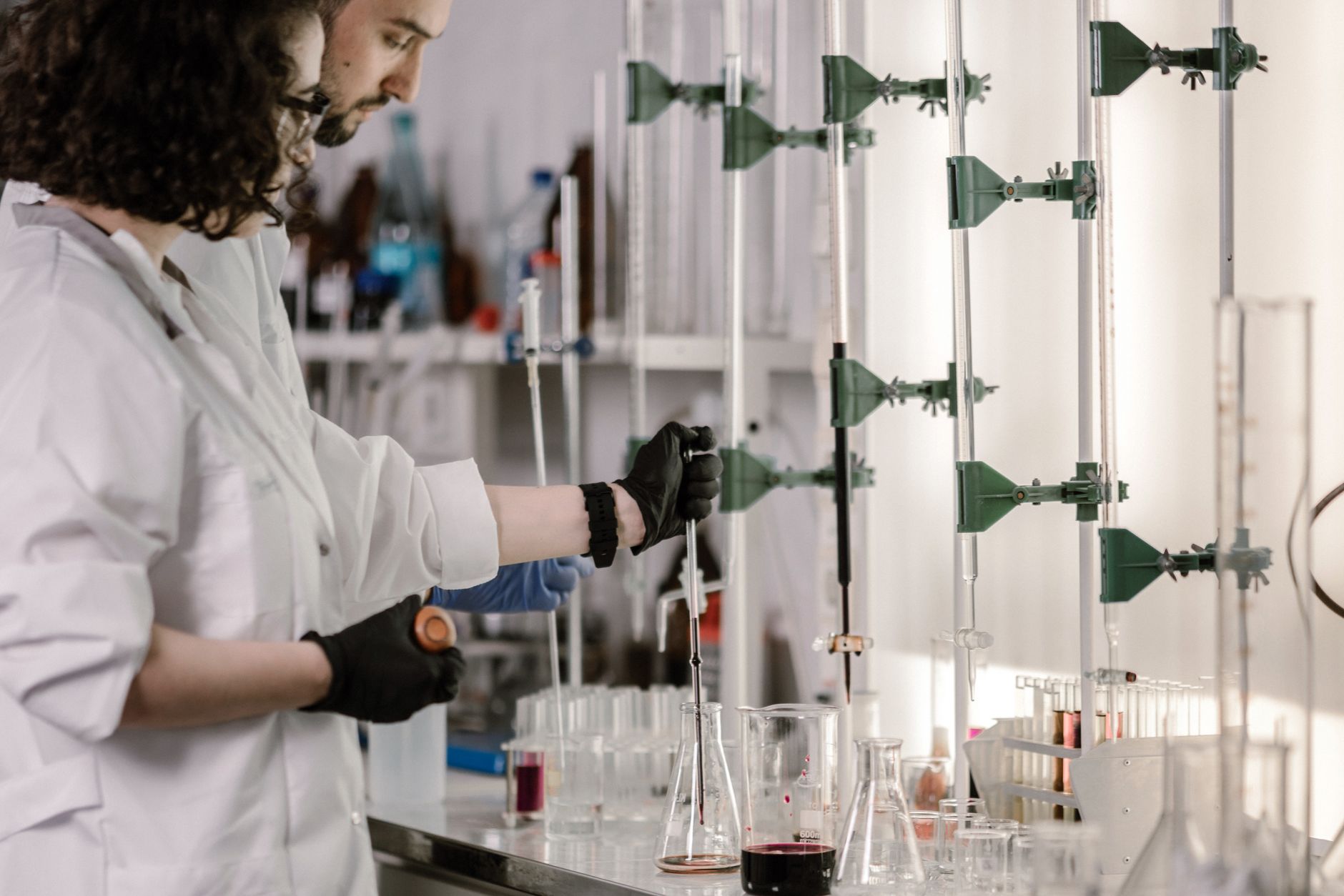 Researchers in lab coats working with test tubes at a modern laboratory bench